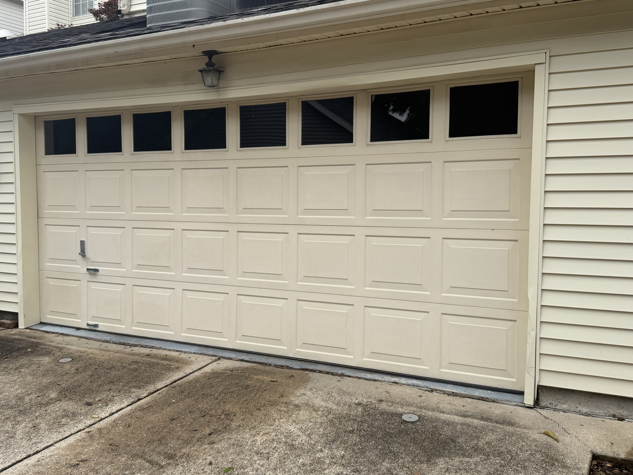 Off-white raised-panel garage door with windows