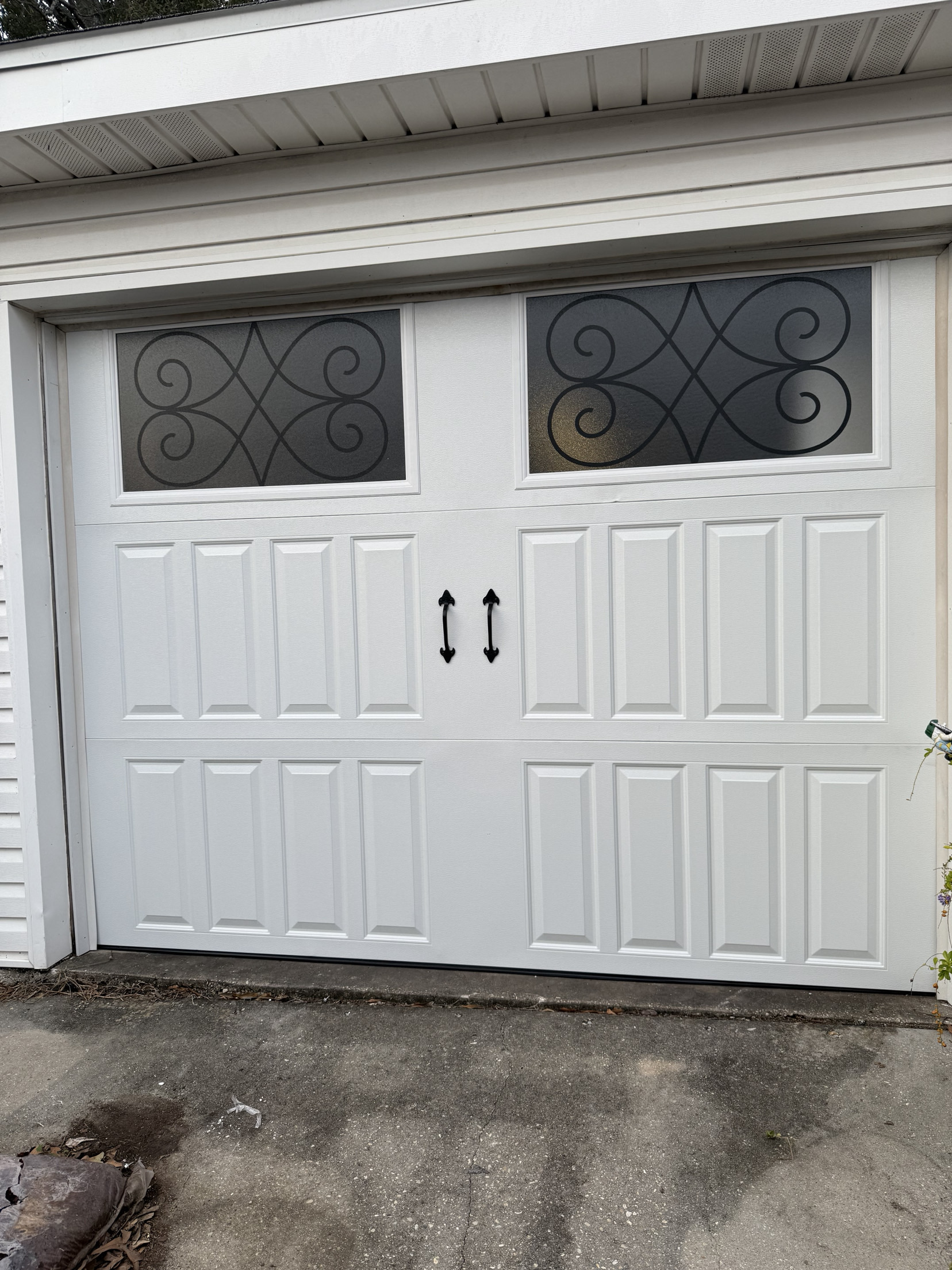 White carriage-style garage door with decorative glass inserts