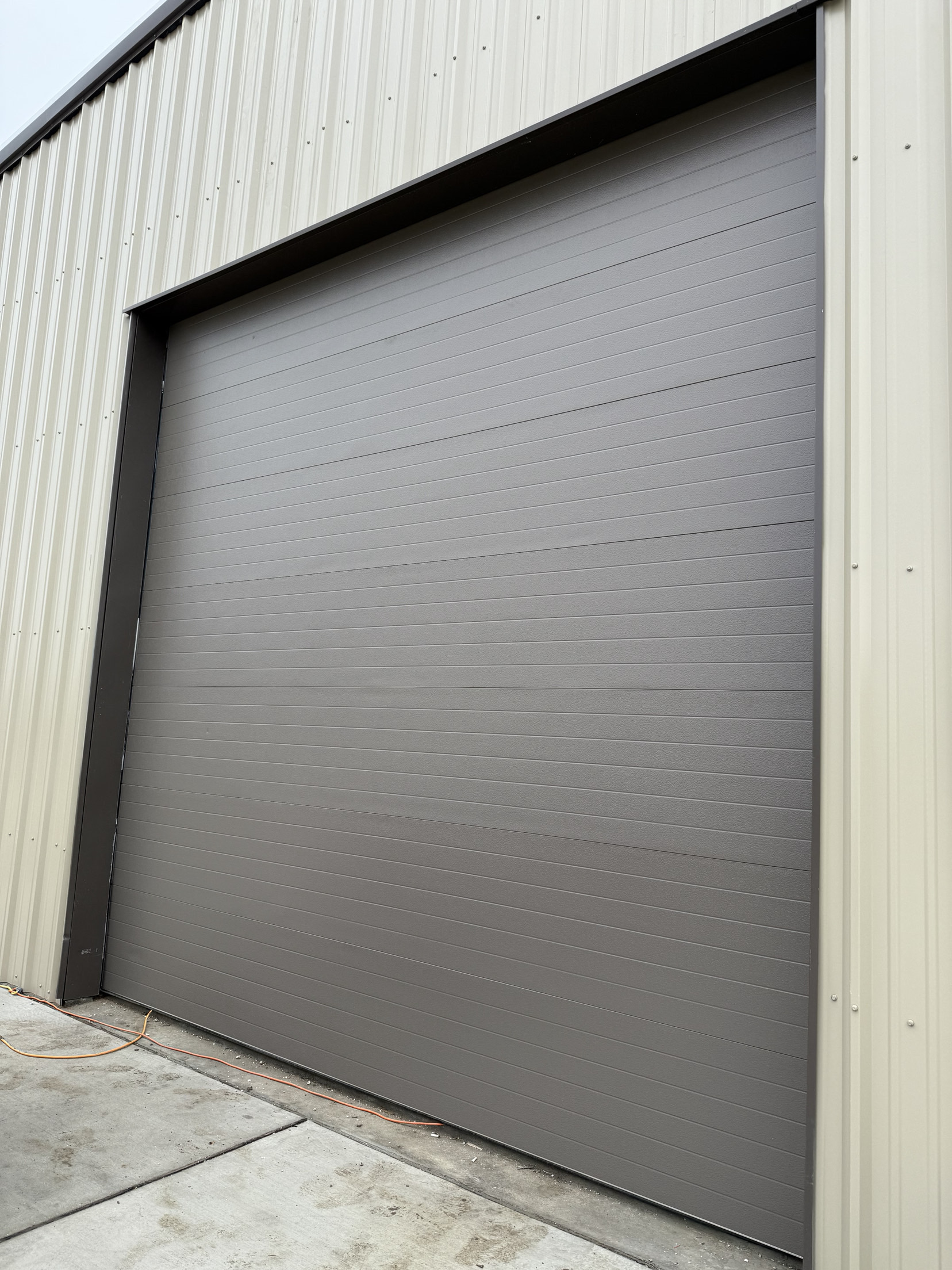 Commercial garage door installation on a metal building